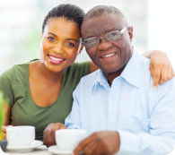 Beautiful young adult african girl and father having coffee at home