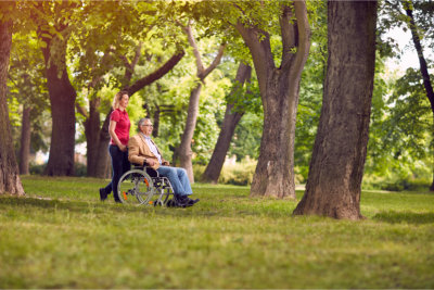 Enjoying senior father in wheelchair and daughter in the park